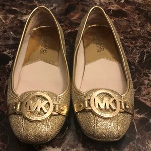 Michael Kors gold flat shoes.